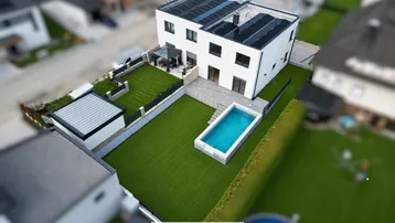 Moderne Villa mit Pool, gepflegtem Garten und Photovoltaikanlage auf dem Dach.