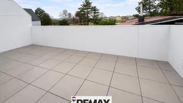 Geräumige Dachterrasse mit hellen Fliesen und weitem Blick über die Umgebung.