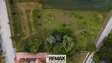 Luftaufnahme eines Grundstücks mit angrenzenden Feldern und einigen Gebäuden.