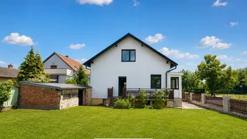 Großer Garten hinter dem Haus mit viel Rasenfläche und Blick auf die Umgebung.
