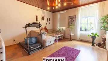 Helles Wohnzimmer mit Holzbalkendecke, Parkettboden und einem Laufband für Fitness.