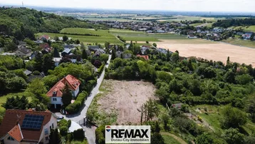 Luftaufnahme eines Baugrundstücks in ländlicher Umgebung mit Blick auf die umliegende Landschaft und Häuser.
