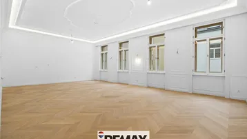Großzügiges, helles Zimmer mit Fischgrätparkett, hohen Decken und dekorativer Stuckdecke.