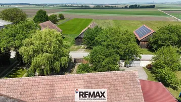 Weitläufige Landschaft mit Feldern, Bäumen und ländlicher Bebauung.