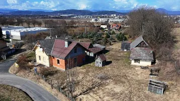 Luftaufnahme eines ländlichen Anwesens mit mehreren Gebäuden und weitem Blick auf die Umgebung.