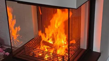 Moderner Kamin mit sichtbaren Flammen, der eine warme und einladende Atmosphäre schafft.