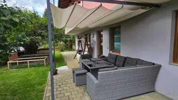 Gemütliche Terrasse mit moderner Pergola und bequemen Loungemöbeln, ideal für entspannte Stunden im Freien.