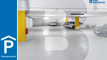 Geräumige Tiefgarage mit mehreren Stellplätzen, hell beleuchtet und mit Betonboden.