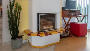 Gemütlicher Wohnbereich mit einem Kaminofen und hellem Holzfußboden.