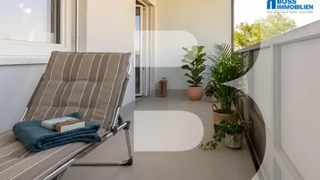 Gemütlicher Balkon mit Liegestuhl und Topfpflanzen, ideal zum Entspannen im Freien.