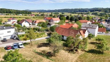 Weitläufige Luftaufnahme des Anwesens und der umliegenden ländlichen Landschaft mit Tilt-Shift-Effekt.