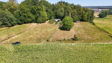 Luftaufnahme des Anwesens mit umliegenden Feldern, Wald und einem kleinen Gebäude.