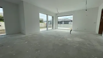 Helles, unfertiges Wohnzimmer mit großen Schiebetüren und Blick ins Grüne.