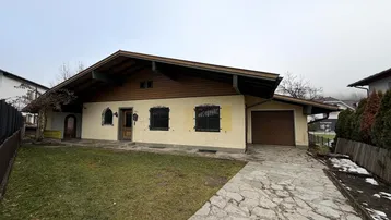 Traditionelles Einfamilienhaus mit Satteldach, Vorgarten und gepflasterter Einfahrt.