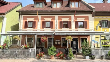 Traditionelles Gebäude mit oranger Fassade, vielen Fenstern und einem verglasten Eingangsbereich.