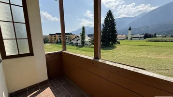 Balkon mit Terrakotta-Fliesenboden und weitem Blick auf die umliegende Landschaft und Berge.