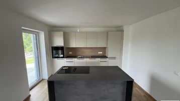 Moderne Einbauküche mit Kücheninsel, Induktionskochfeld und integriertem Backofen.