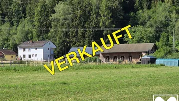 Ländliches Anwesen mit Wohnhaus, Nebengebäuden und großem Garten, umgeben von Wald und Natur.