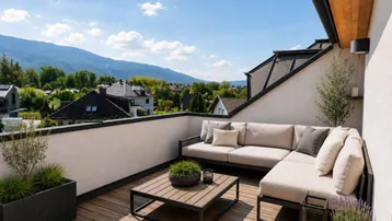 Geräumige Dachterrasse mit bequemen Loungemöbeln und atemberaubendem Bergblick unter blauem Himmel.