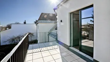 Sonniger Balkon mit Fliesenboden und Blick auf die Umgebung, ideal für Entspannung im Freien.