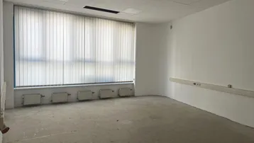 Heller, leerer Raum mit großen Fenstern und Heizkörpern, bereit für die individuelle Gestaltung.