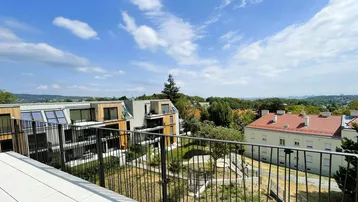 Panoramablick von der Terrasse auf die umliegende grüne Landschaft und die Stadt.