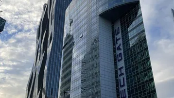 Moderne Bürogebäude mit Glasfassaden und markanter Architektur unter bewölktem Himmel.