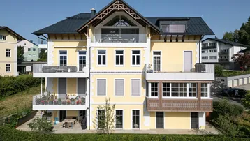 Seitenansicht des modernen Gebäudes mit mehreren Balkonen und Terrassenbereichen.