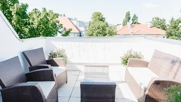 Geräumige Dachterrasse mit bequemen Loungemöbeln und Blick auf die Umgebung.