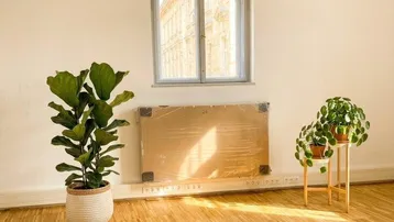 Heller Raum mit Holzboden, großem Bogenfenster und modernen Deckenleuchten, in sehr gutem Zustand.