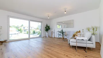 Helles Wohnzimmer mit großen Schiebetüren, Holzboden und moderner, heller Einrichtung.