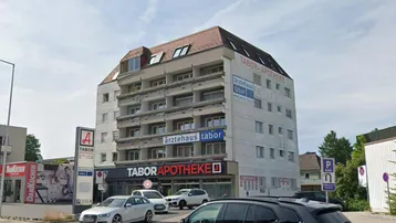 Ansicht des Mehrzweckgebäudes mit Apotheke und Arztpraxen im Erdgeschoss und oberen Etagen.