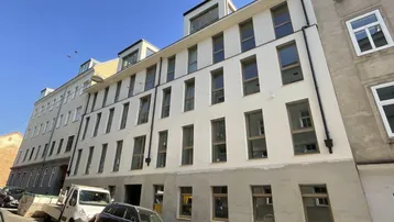 Moderne Gebäudefassade eines Neubaus in städtischer Umgebung mit vielen Fenstern.