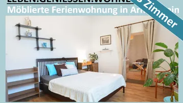 Helles Schlafzimmer mit Holzbett, modernen Regalen und offenem Zugang zu einem weiteren Wohnbereich.