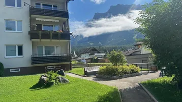 Mehrfamilienhaus mit Balkonen und Blick auf die majestätischen Berge.