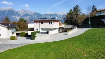 Wohnhaus mit moderner Architektur, Photovoltaikanlage auf dem Dach und beeindruckendem Bergblick.