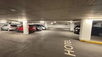 Geräumige Tiefgarage mit zahlreichen Stellplätzen und klarer Beschilderung für Hotelgäste.