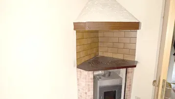 Gemütliche Ecke mit einem Kaminofen und Parkettboden, ideal für kalte Abende.