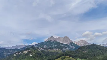 Panoramablick auf die beeindruckende Bergwelt und grüne Täler.