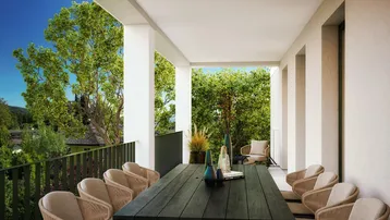 Großzügige überdachte Terrasse mit Esstisch und Blick ins Grüne, ideal für Mahlzeiten im Freien.