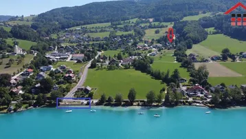 Luftaufnahme der malerischen Seenlandschaft mit umliegenden Häusern und grüner Natur.