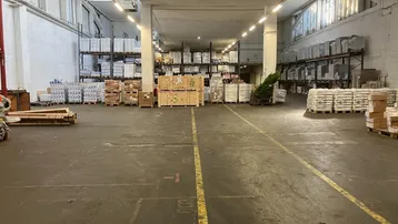 Geräumige Lagerhalle mit hohen Decken, Betonboden und Regalsystemen für vielfältige Nutzungsmöglichkeiten.