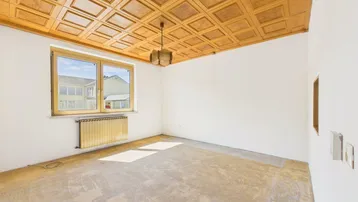 Heller Raum mit Holzkassettendecke und Fenster, bereit für neue Bodenbeläge.