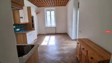 Küche mit Einbauschränken, Fliesenrückwand und Fischgrätparkettboden in einem hellen Raum.