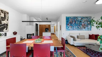 Geräumiger Wohn-Essbereich mit Kamin, Holzboden und moderner Einrichtung, ideal für geselliges Beisammensein.