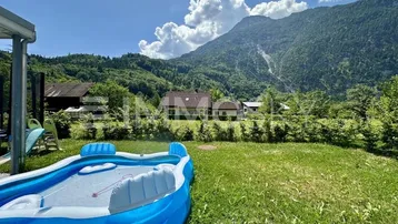 Großer Gartenbereich mit aufblasbarem Pool, Rasenfläche und beeindruckendem Bergblick.
