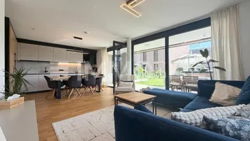 Moderner offener Wohn- und Essbereich mit integrierter Küche und Zugang zur Terrasse.