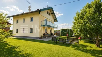 Großer, gepflegter Garten mit Rasenfläche, Terrasse und Sitzgelegenheiten hinter dem Haus.