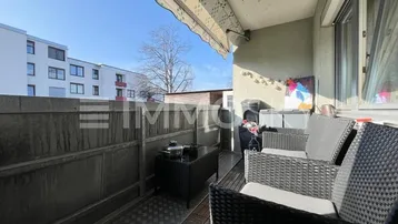 Balkon mit Sitzgelegenheiten und Markise, bietet einen Blick auf die umliegenden Gebäude.