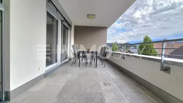 Geräumiger Balkon mit Fliesenboden, Sitzgelegenheiten und weitem Blick in die Landschaft.